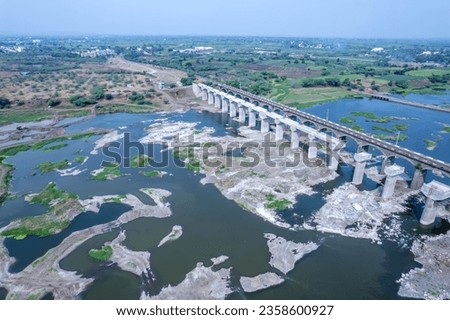 Aerial footage of the River Bhima and surrounding landscape including bridges at Daund India. Royalty-Free Stock Photo #2358600927