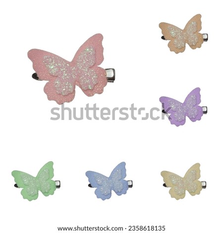 Butterfly hair clips with 6 different colors of glitter on a white background. Royalty-Free Stock Photo #2358618135