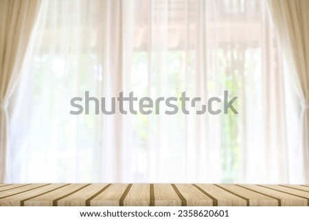 wooden counter table top on the window background with white curtains can see a blurry garden of trees. of spring. Ideas for designing key image layouts and editing product displays and space empty
