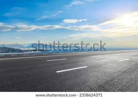 Asphalt highway and sea with island natural landscape at sunset Royalty-Free Stock Photo #2358624371