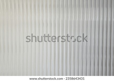 A Close up of corrugated glass texture with reflected,modern home decor,stylish home decor,Creative composition of living room,Wave glass vertical line pattern,Template. Royalty-Free Stock Photo #2358643431