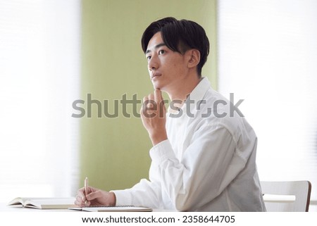 Japanese male university student studying in the university library Royalty-Free Stock Photo #2358644705