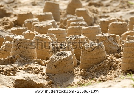Close up of series of sand castles built in a sandpit 