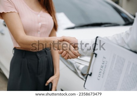 Automotive business, car sale or rental concept Customer with car dealer agent making deal and signing on agreement document contract in auto showroom or on street

