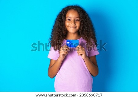 Photo of beautiful kid girl with afro curly hairstyle wearing pink T-shirt positive smile hold credit card income salary