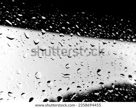 Large raindrops grace the window glass after a heavy summer downpour. An overcast sky sets a contemplative backdrop for this close-up portrayal of nature's tears