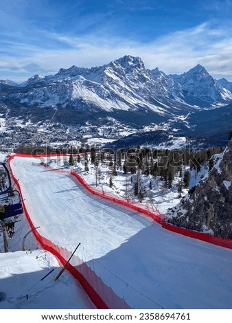 Scenic view of Tofana ski racing slope in Cortina d'Ampezzo in Italy against snow covered Punta Sorapiss Mountain (middle) and Antelao (right) Royalty-Free Stock Photo #2358694761