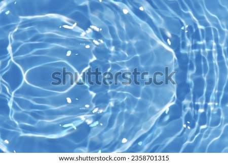 Blue water with ripples on the surface. Defocus blurred transparent blue colored clear calm water surface texture with splashes and bubbles. Water waves with shining pattern texture background. Royalty-Free Stock Photo #2358701315