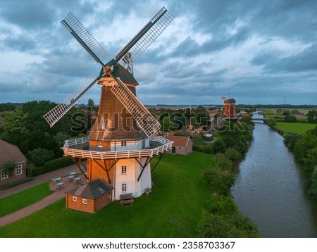Aerial view of twin mills at Old Greetsieler Sieltief in Greetsiel. State of Lower Saxony in Germany Royalty-Free Stock Photo #2358703367