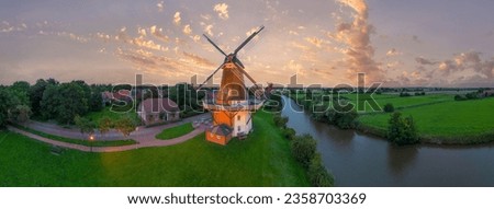 Aerial view of twin mills at Old Greetsieler Sieltief in Greetsiel. State of Lower Saxony in Germany Royalty-Free Stock Photo #2358703369