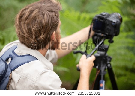 photographer as a nature photographer with camera and tripod