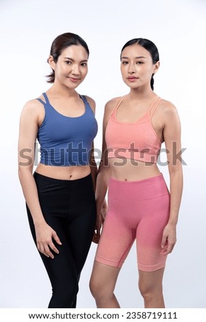 Two asian women in sportswear full body portrait, smiling and posing cheerful gesture. Workout training with attractive girl engage in her pursuit of healthy lifestyle. Isolated background Vigorous