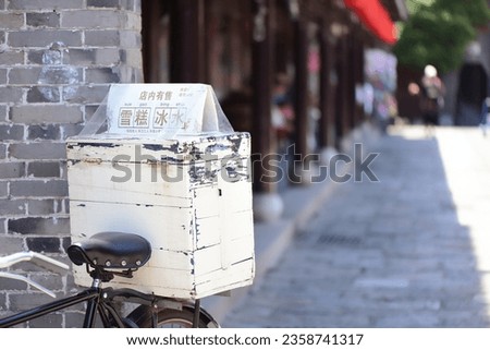 A box selling ice cream and ice cream on a retro bicycle in an ancient summer town. The Chinese character in the picture means: the store sells ice cream and beverages