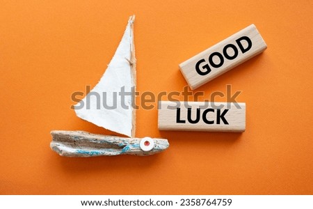 Good luck symbol. Wooden blocks with words Good luck. Beautiful orange background with boat. Business and Good luck concept. Copy space.