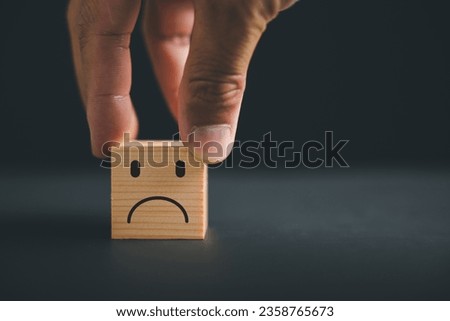 Customer Experience dissatisfied concept. Unhappy customer expressing dissatisfaction on a wooden block. Bad review, low rating, and negative feedback affect business reputation in online marketing.