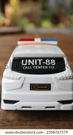 White police car toy seen from the side with a blurred background