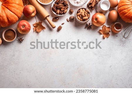 Autumn fall baking background with pumpkins, apples, nuts, food ingredients and seasonal spices. Cooking pumpkin or apple pie and cookies for Thanksgiving and autumn holidays.