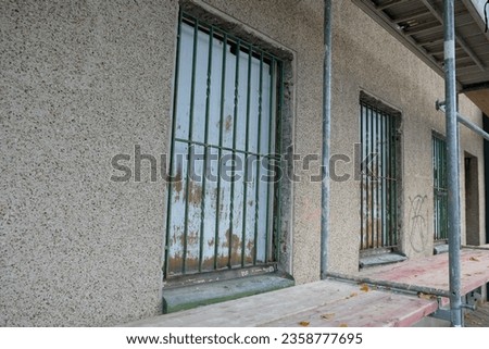 in the wall of the house is a barred window