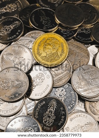 a golden coin on silver coins