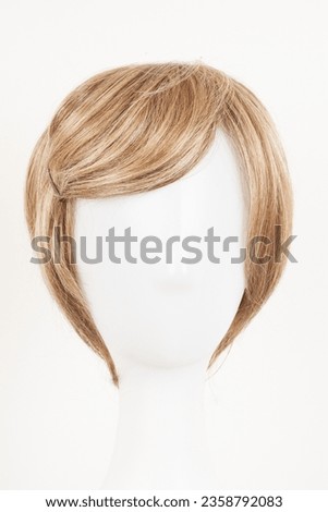 Natural looking blonde fair wig on white mannequin head. Short hair cut on the plastic wig holder isolated on white background, front view
 Royalty-Free Stock Photo #2358792083