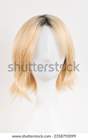 Natural looking blonde fair wig on white mannequin head. Short hair cut on the plastic wig holder isolated on white background, front view
 Royalty-Free Stock Photo #2358792099