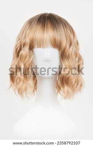 Natural looking blonde fair wig on white mannequin head. Middle length hair cut on the plastic wig holder isolated on white background, front view
 Royalty-Free Stock Photo #2358792107