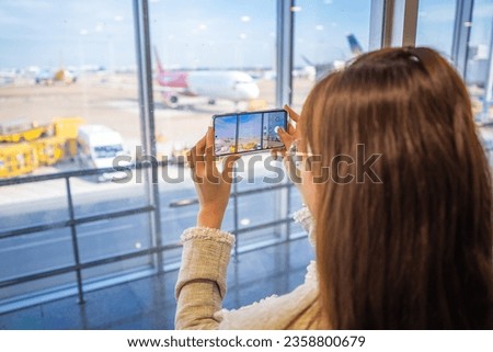 Girl taking picture thru the window on the moving walkway