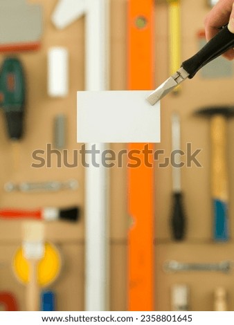 DIY and home improvement banner with work and construction tools on a  workbench top view, blank white business card at centre