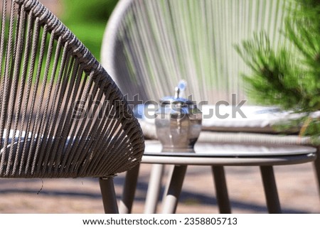 Synthetic gray rattan chair in the garden. Close up.