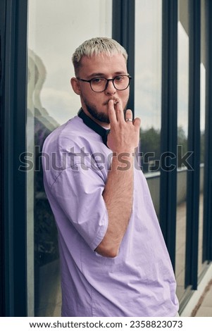 In front of a modern glass building, a young, blond influencer strikes a confident pose, epitomizing urban glamour and style in the heart of the city