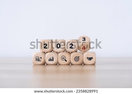 2024 trend concept. flip wooden cube change year 2023 to 2024. gray background with icon marketing, finance, business, trend, target, and investment for plan to goals, marketing strategy concept