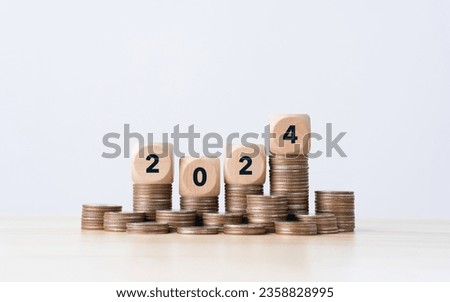 the number year 2024 in wooden cubes on top stack of coins. financial annual plan for money, Budget, tax, investment, financial, savings, and New Year Resolution concepts Royalty-Free Stock Photo #2358828995