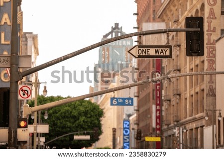 A traffic light with one way sign with high Buildings in 6th street in Los Angeles, California