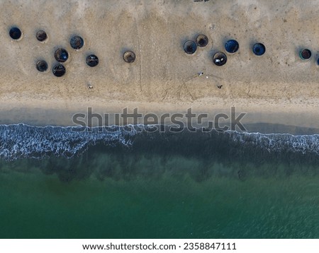 Beach shot from above with basket boats of Vietnamese fishermen on sand and sea waves during the day.  Nobody.  Concept of tourism and fishery.