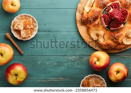 Jewish Holidays - Rosh Hashanah or Rosh Hashana. Pomegranate, apples, honey and round challah on  old wooden blue table background. Jewish Autumn celebration. Shana Tova. Yom kippur concept. Top view