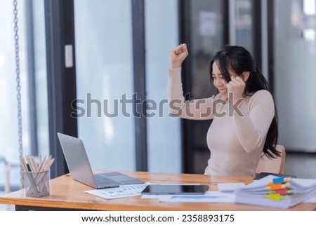 Young  business woman manager, holding accounting bookkeeping documents checking financial data or marketing report working in office with laptop. Paperwork management