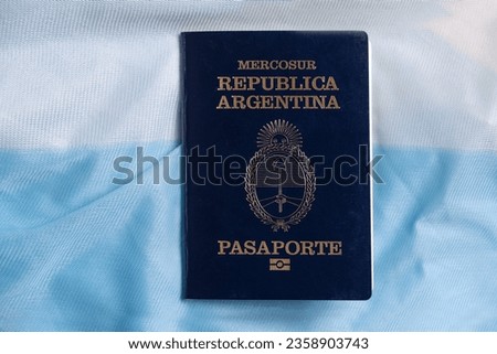ARGENTINE PASSPORT OVER ARGENTINE FLAG.