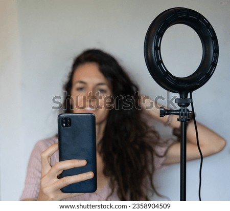 Girl with ring of light recording with mobile