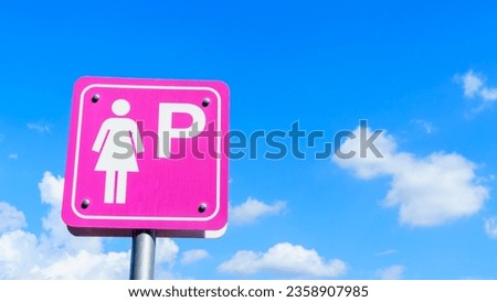 Pink lady parking sign with cloudy blue sky background and copy space.