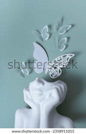 Plaster head with butterflies on a colored background. Mental health concept. World mental health day. Royalty-Free Stock Photo #2358911015