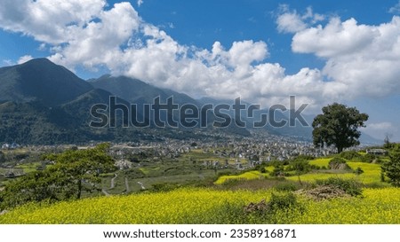 A scenic view of a green landscape with a town on a slope of Himalaya Foothills Royalty-Free Stock Photo #2358916871