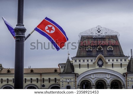 The North Korean flag and the building of Vladivostok railway station with the word "Vladivostok" (in Russian), before North Korea leader Kim Jong Un's visit to Primorsky krai, Russia in April 2019. Royalty-Free Stock Photo #2358921453