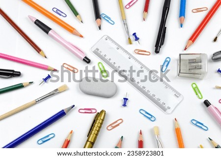 Bright set for school, stationery on a white background. Colored pencils, pens, plastic paints and paper clips, flat layers with space for text.