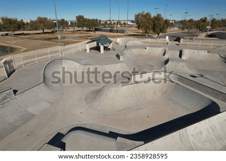 This is an empty skate park with ramps and benches next to it