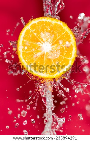 orange in water on a red background background