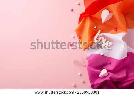 Commemorate International Lesbian Day with this top view image of the Lesbian Pride flag, heart icons, "love" script against a pastel pink background