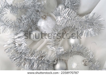 Different types of Christmas balls, silver balls, glass balls for Christmas tree decoration, no people, flat lay image on white fabric, calm minimalistic atmosphere, classy style decor, winter