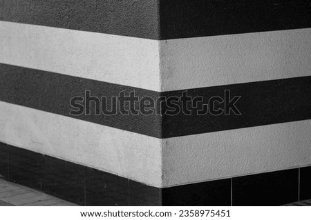Contrasting Black and White Stripes on a Corner Wall.