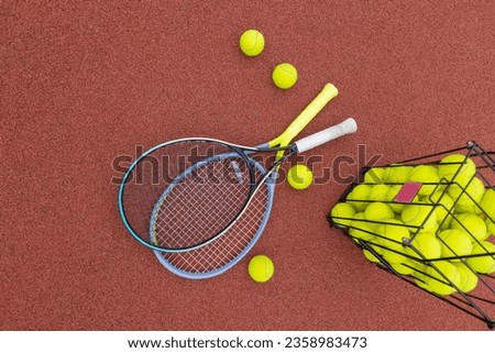 two tennis rackets on a court with balls