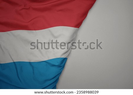 big waving national colorful flag of luxembourg on the gray background. macro
